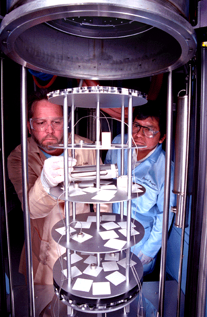 Sandians Doug Foldie, left, and David Fragua prepare neutron tube subassemblies for joining in a computer-controlled and electrically heated hydrogen furnace. The hydrogen atmosphere eliminates oxidation of metal piece parts.