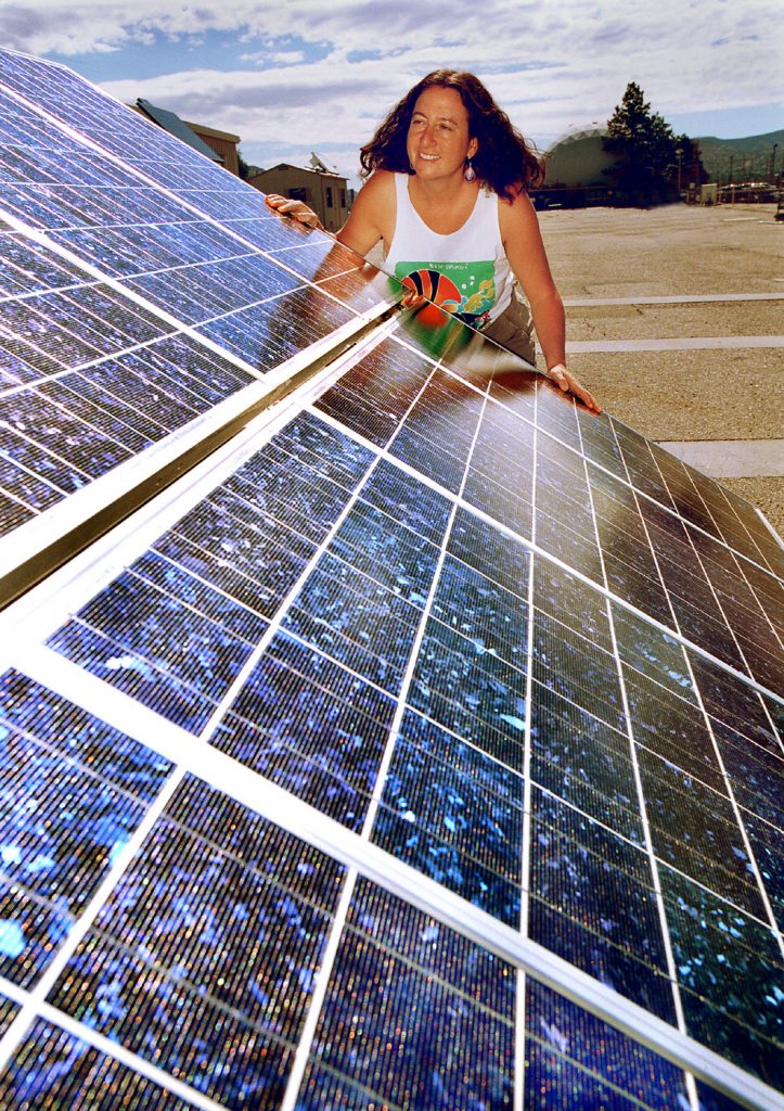 NAVAJO SOLAR POWER INITIATIVE -- Sandia National Laboratories engineer Marlene Brown checks out a photovoltaic unit like the ones she helps Navajo families use and maintain at their homes.