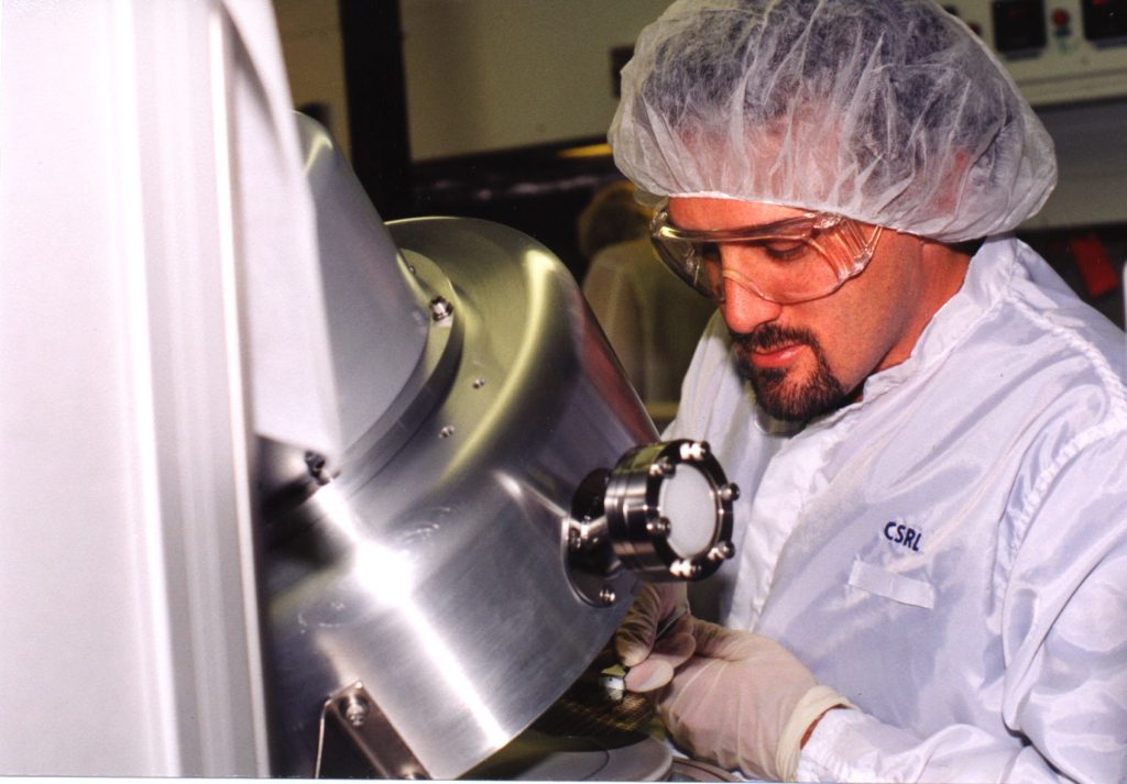 TINY CHEMICAL SAMPLING DEVICE — Sandia researcher Ron Manginell examines a superminiaturized preconcentrator used to collect sample gases for analysis.