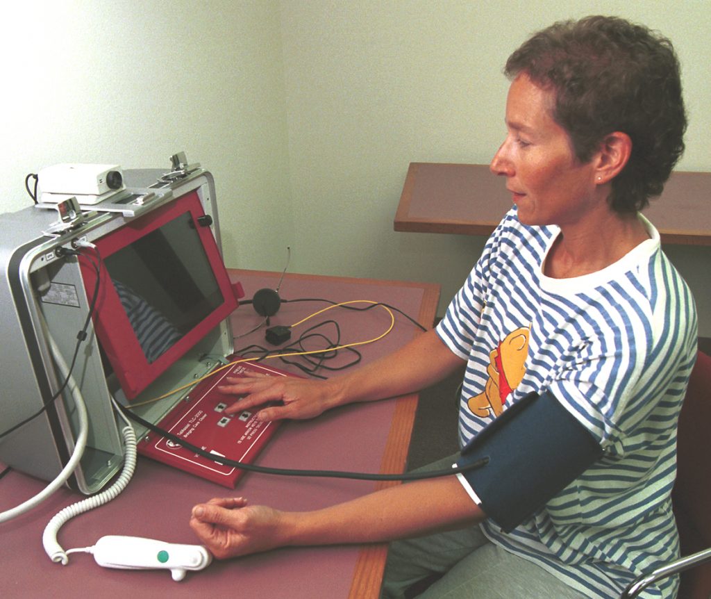 Sandia's Linda Gallagher checks her blood oxygenation and pressure with sensors connected to a state-of-the-art unit from TelAssist Corp. The work is part of a Sandia effort to develop secure online telemedicine techniques.