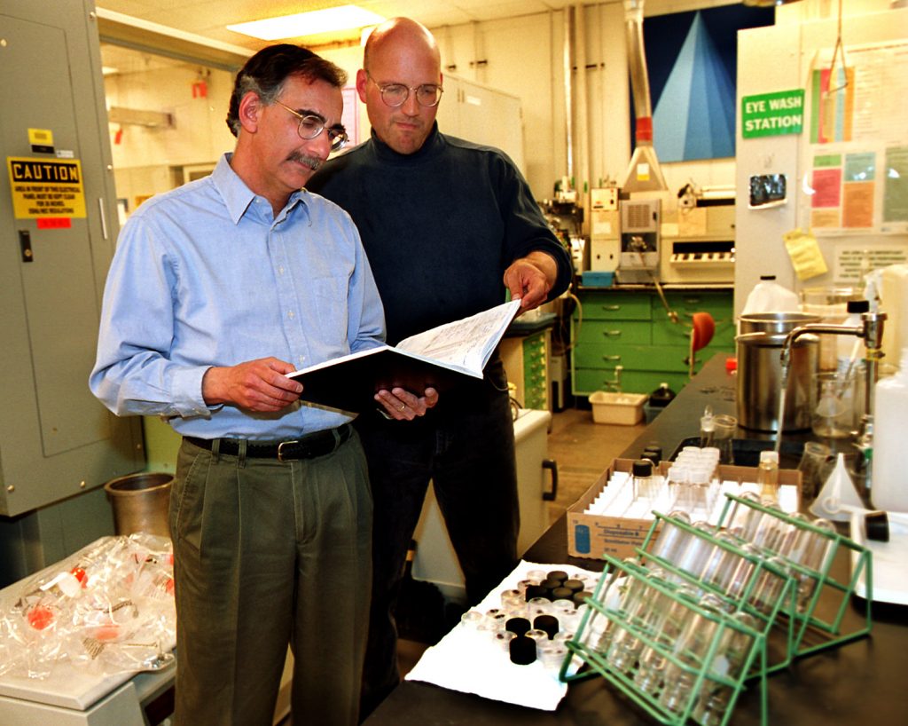 THE NATURAL WAY -- Sandia scientists Malcolm Siegel, left, and Pat Brady, review notes in their laboratory. They are researching natural attenuation, a "natural" alternative to cleaning up uranium-contaminated sites.