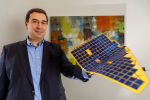 Murat Okanden, CTO and founder of mPower Technology Inc., demonstrates the flexibility of the company's DragonSCALES photovoltaic arrays. (Photo by Bret Latter) Click on the thumbnail for a high-resolution image.