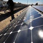 researcher looking at solar panels