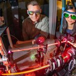 scientists observe laser recording measurements in wind tunnel