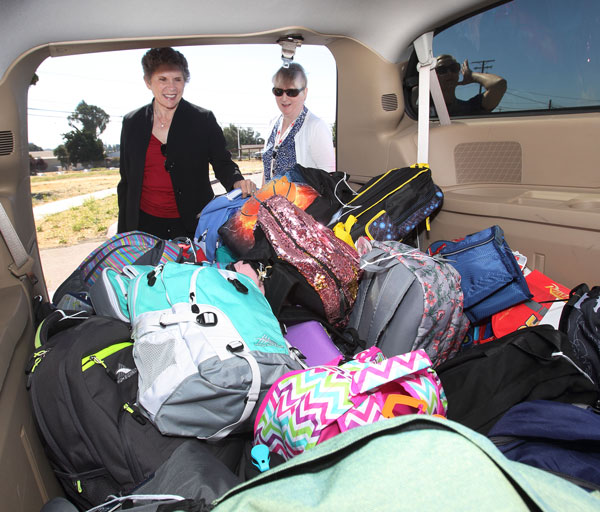 THE LOAD OUT — Division 8000 Associate Laboratories Director Dori Ellis and Rachael Gupta help load a van with backpacks donated by Sandians.