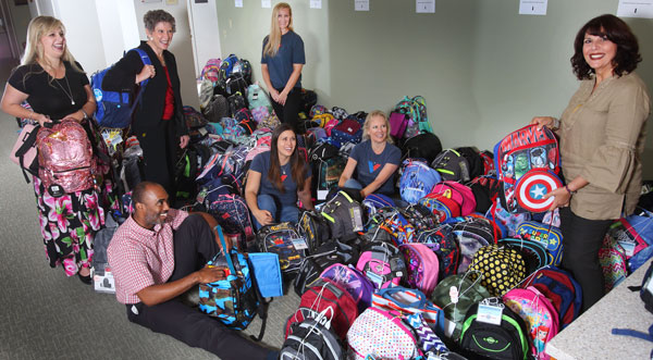 PACKING — Division 8000 Associate Laboratories Director Dori Ellis (second from left) talks to Operation Backpack volunteers before loading the backpacks.