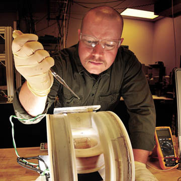 KYLE SOLIS (in photo at left), a graduate student intern in Nanomaterials Sciences Dept. 1112, prepares a sample for mixing using a new approach called vortex field mixing, developed by researchers in his organization.	(Photo by Randy Montoya)