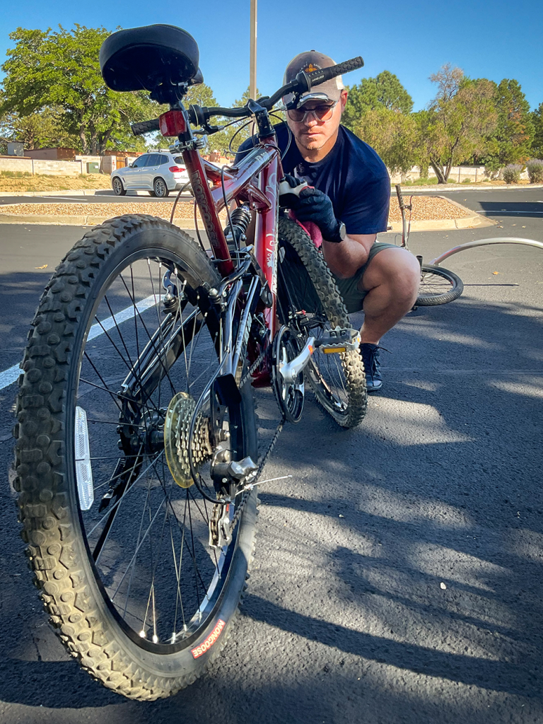 GIVING BACK WHAT WAS GIVEN TO HIM — Levi Allen repairs a donated bike that will go to a child in need as part of Sandia Serves Day, a way of helping pay it forward (Photo by Katrina Wagner)