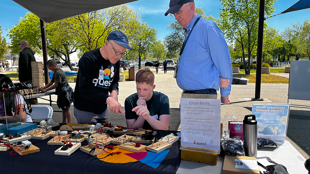 KIDS DAY — Quest Science Center Director Rick Stulen, left, a Sandia retiree who served as vice president of the California site, shows a student how circuit boards function at Sandia’s Kids Day in Livermore on April 22. (Photo by Spencer Toy)