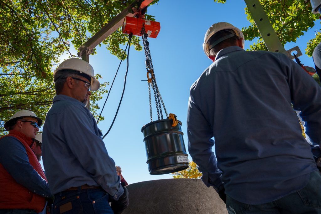 LOWERING THE CAPSULE — A new time capsule is lowered at Sandia's 75th anniversary event on Oct. 31. The capsule replaces one that was placed during Sandia's 50th anniversary celebration. (Photo by Craig Fritz)