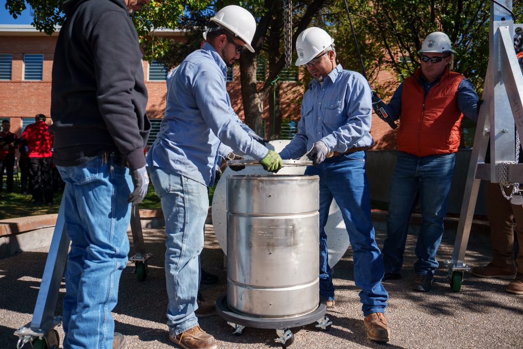 BREAK THE SEAL — Members of the Facilities team open the time capsule that was sealed in 1999 during the 50th anniversary time capsule event. (Photo by Craig Fritz)