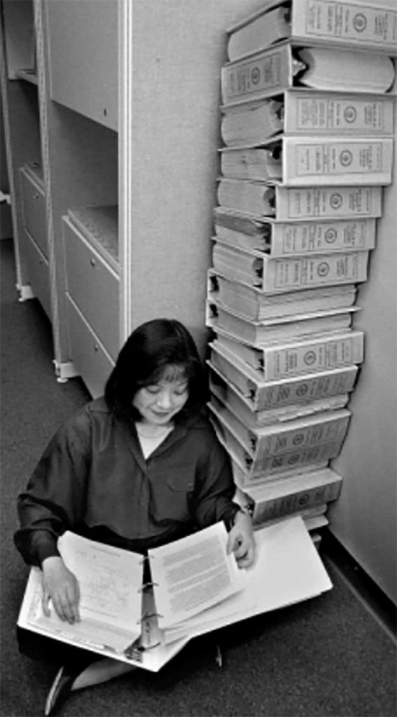 A MONUMENTAL CHALLENGE — Margaret Chu reads one of 21 volumes of the Compliance Certification Application for WIPP. (Photo from a report by Carl J. Mora)