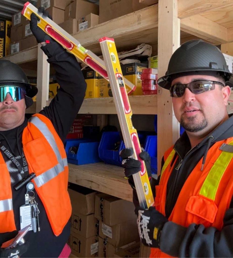 STAGING SPACE — From left, mechanical tradesmen Daniel Sena and Eric Jinzo set up storage containers for new construction tools, equipment and staging area. (Photo courtesy of Lyndsy Ortiz)