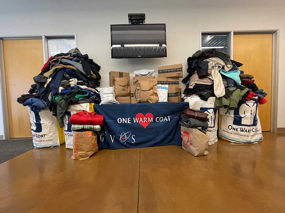 COATS FOR ALL — Coats are piled high and sorted on Dec. 6, for the 13th Annual One Warm Coat Drive, led by Sandia California as part of the Sandia Gives campaign. Staff donated 335 coats, exceeding their goals for the drive. One Warm Coat raises awareness of the need for coats and partners with nonprofits across the U.S. to distribute them. (Photo by Krissy Galbraith)