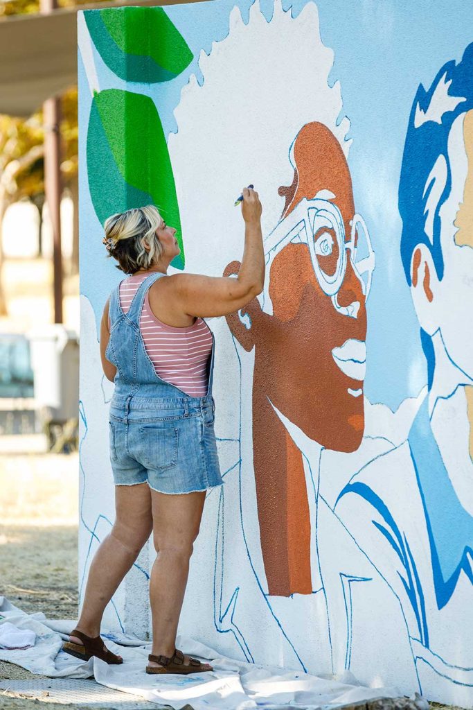 MURAL IN MOTION — Krissy Galbraith paints the mural on Sandia California’s east entrance.