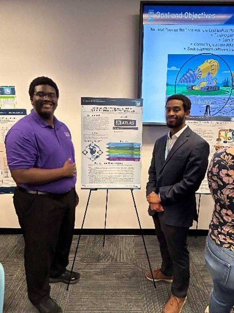 AI IN ACTION — Interns Josiah Moore, left, and Kenneth Howard present their research project ATLAS, an AI-assisted tool designed to help quality engineers with complex processes and questions. (Photo courtesy of Breanna Gallegos-Schnedar)